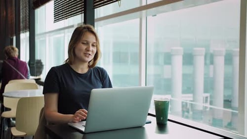 Mulher gerente usando laptop assistindo vídeo de aula de seminário on-line conversando com colegas no local de trabalho
