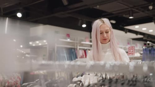 Woman Browsing Clothing Rack And Admiring Garment