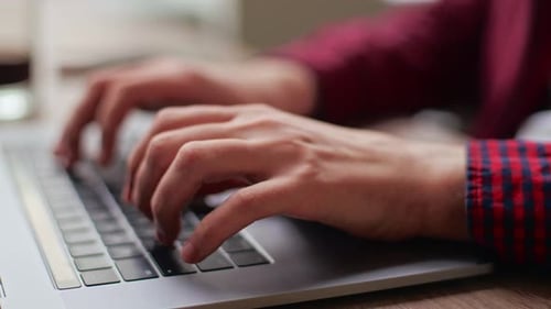 Nahaufnahme des Entwicklers von Freelancer beim Coworking beim Tippen von Programmcode auf der Laptop-Tastatur