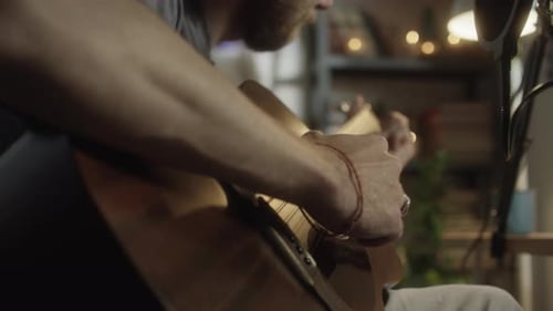Man Playing Guitar in Home Recording Studio