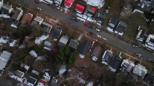 Houses and homes during snowy day in american suburb. Aerial top down flyover. Quiet and peaceful ho
