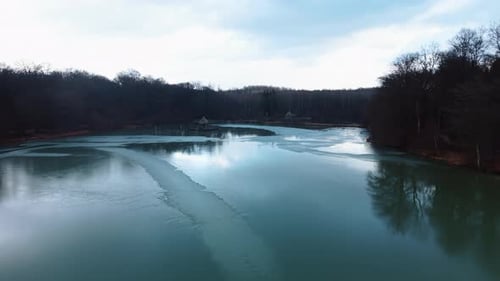 Aerial: frozen Verchat pond and Cabanes des Grands Reflets during the day in Joncherey, France