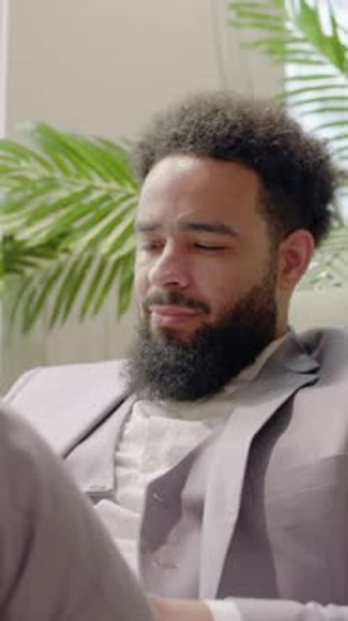 A Professional African American Man is in a Sleek Modern Office Focused on His Work