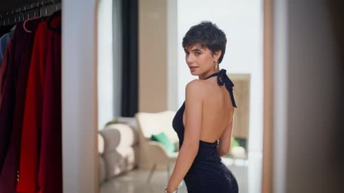 Elegant Woman Models Blue Dress in Front of Mirror