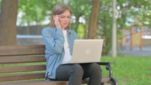 Woman Working on Laptop in Park Gets Headache