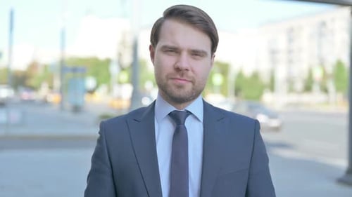 Confident Businessman in Suit Stands Outdoors