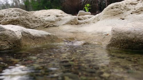 El agua de un río pequeño fluye sobre grandes rocas