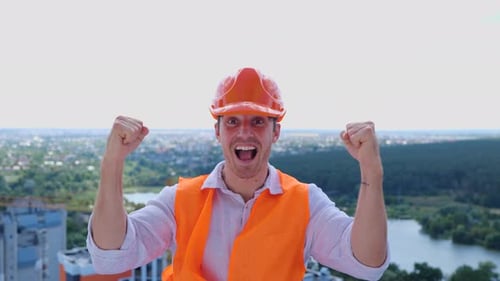 Construction Worker Cheering on Top of Building