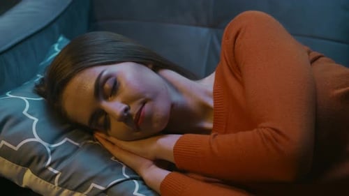 Woman Asleep Peacefully on Sofa at Night