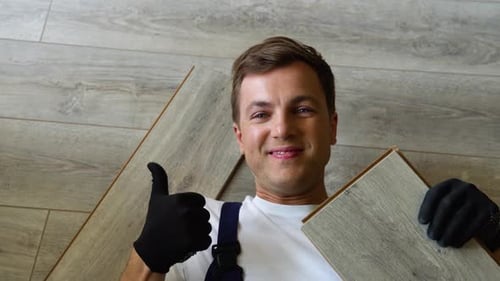 Smiling Man Lies on New Flooring and Approves