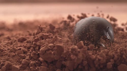 Chocolate Truffle Dropping into Mound of Cocoa Powder