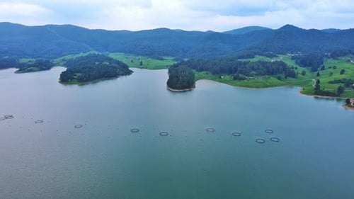 Fishing Cages for Breeding Fish in Lake in Mountain Valley of Rhodope Mountains Under Cloudy Sky