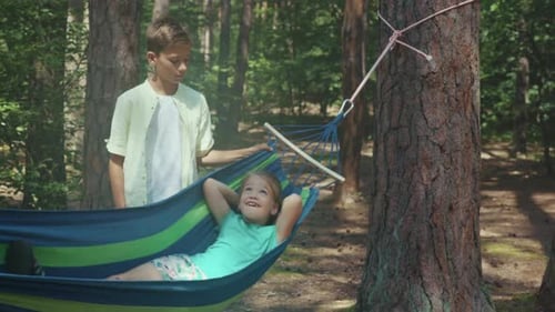 Girl Relaxing in Hammock with Friend in Forest