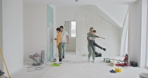 Family Improves Home Together, Mother and Son Playfully