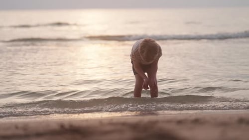 Child Playing in the Surf at Sunrise