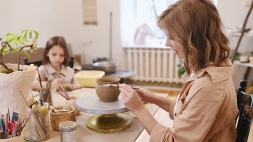Woman and Child Creating Pottery Art Together at Home
