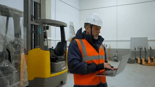 Ingenieur untersucht die Räumlichkeiten eines Laptops mit Lagerhaltung