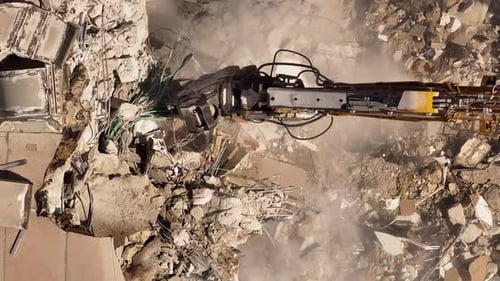 Building demolition excavator using Pulverizer Jaws to demolish a residential building