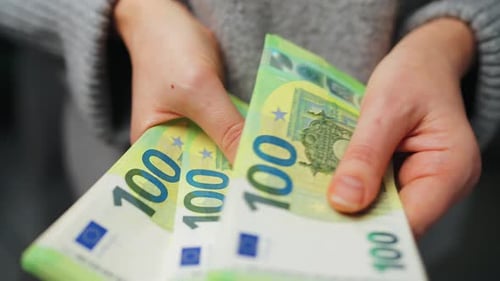 Женщина, считающая банкноты евро — снимок крупным планом