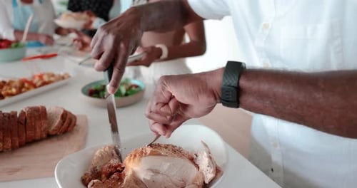 Close Up Senior Man Carving Chicken Meat for Family Dinner in Kitchen 1617 Years