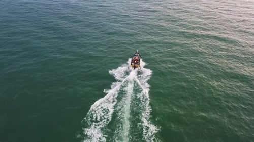 Aerial above view capturing small traditional small fishing boat sailing on the sea.