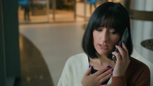 Woman Talking on Cellphone Inside Building