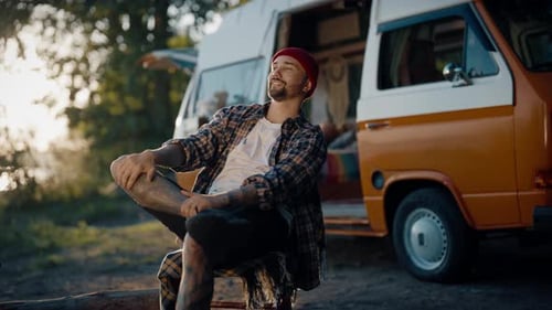 Man Relaxing Outside Orange and White Van