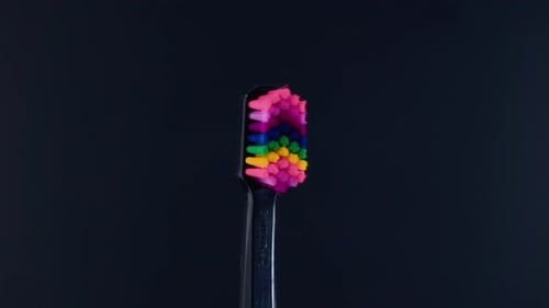 Colorful Bristle Toothbrush Rotating on Black Background