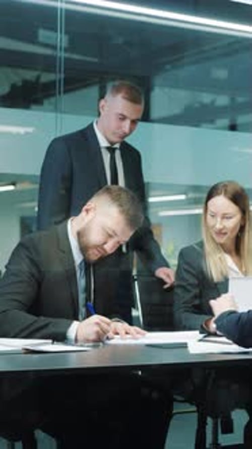 Corporate Business Team Signs Documents and Shakes Hands