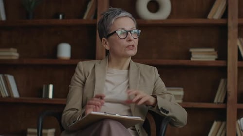 Senior Therapist Sitting and Talking Close Up Mature Woman in Eyeglasses Speaking