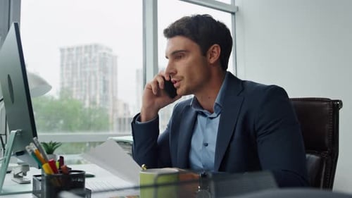 Focused Man Talking on Phone in Office Setting