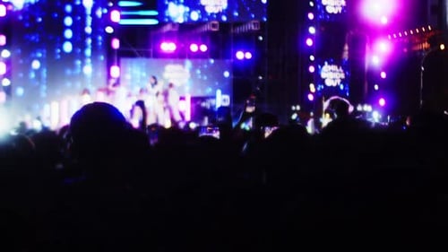 Soft Focus Pop Band Concert on Street at Night Silhouettes Fans Raise Their Hands in Front Bright