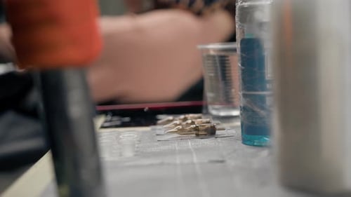 Tattoo artist prepares needles for procedure