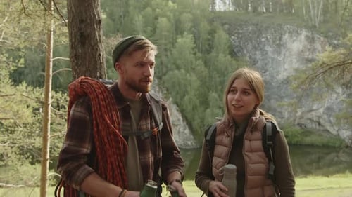 Couple Discussing Hiking Route and Drinking Water in Forest