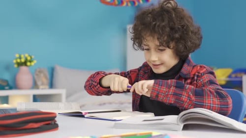 Primary school student doing homework at the desk is studying with pleasure.