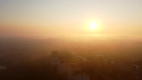 Bright Shining Sun at Dawn Fog Over Rooftops of Multistorey Buildings