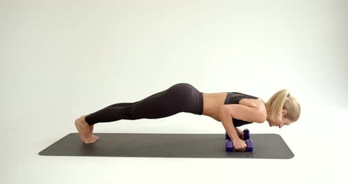 Woman Working Out Doing Pushups on Dumbbells