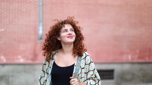 Happy Young Woman Walking Through Sunny City Streets