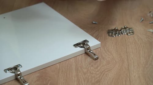 Vis à main avec tournevis dans l'assemblage de la charnière de la porte et du meuble