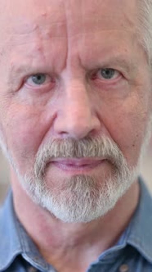 Close up of Serious Old Man Looking at the Camera, vertical video