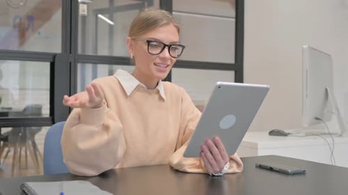 Female Worker Doing Video Chat on Tablet in Office