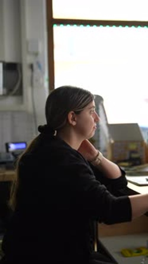 A Woman is Deeply Focused and Concentrating at Her Office Desk Working on a Computer