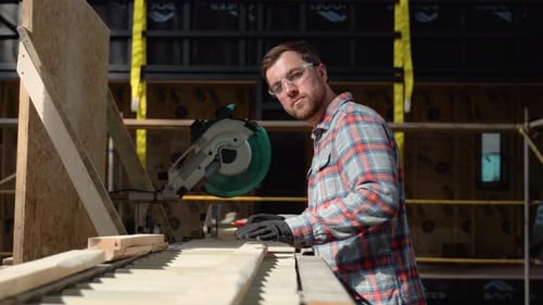 Builder Saws a Board with a Circular Saw in the Cutting a Wooden Plank