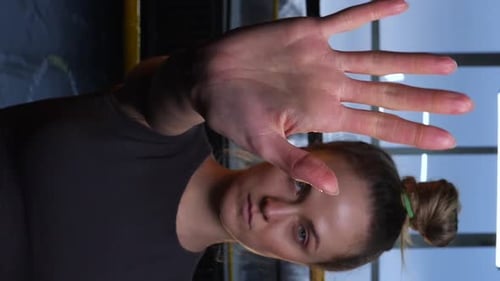 Vertical Video Beautiful Girl with a Stern Look Shows a Stop Hand Gesture
