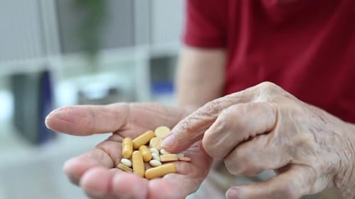 Senior Hands Displaying and Picking at Medication