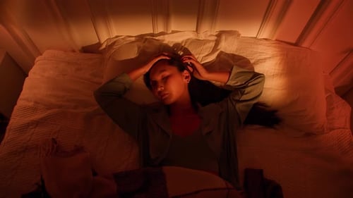 Woman Lying in Bed with Headache in the Evening