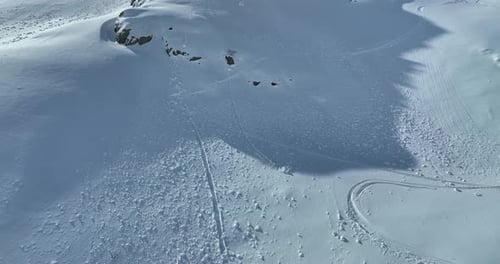Aerial Rising Drone Shot Over Leafless Trees Above a Snowy Mountain Winter Wilderness on a Sunny Day