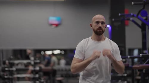 Bald Man Warming Up Before Starting His Fitness Workout at the Gym