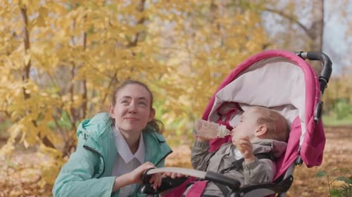 Feeding Scene with Nanny and Baby in Cozy Park Setting An Attentive Caregiver Offering Nourishment