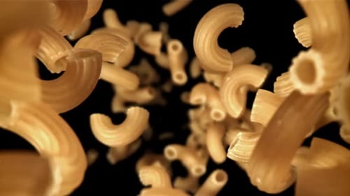 Elbow Macaroni Floating Against Black Background